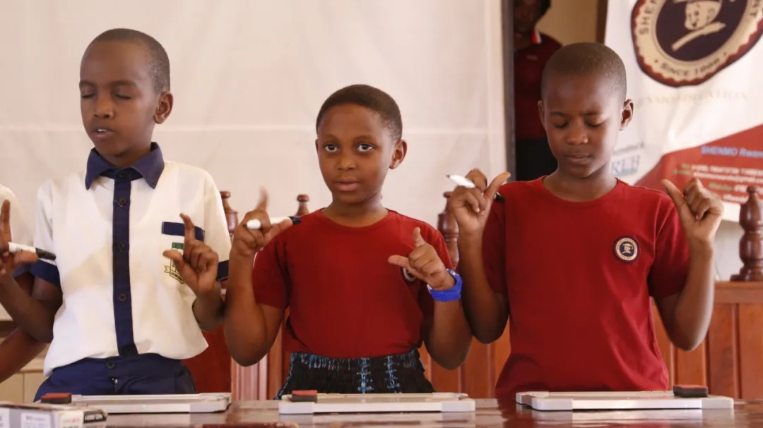 Shenmo Education Rwanda — Abacus Mental Math practice: students using hand visualization and whiteboards during a center session.