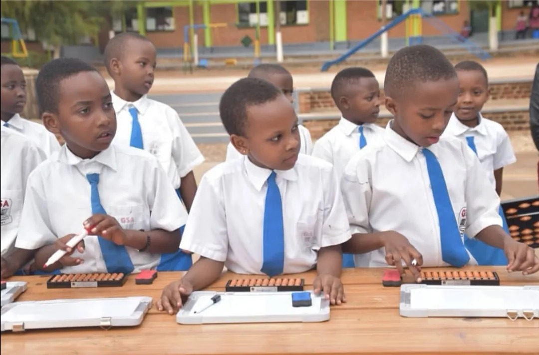 Shenmo Education Rwanda — Partner-school lesson: pupils in uniform practicing with the abacus and whiteboards.