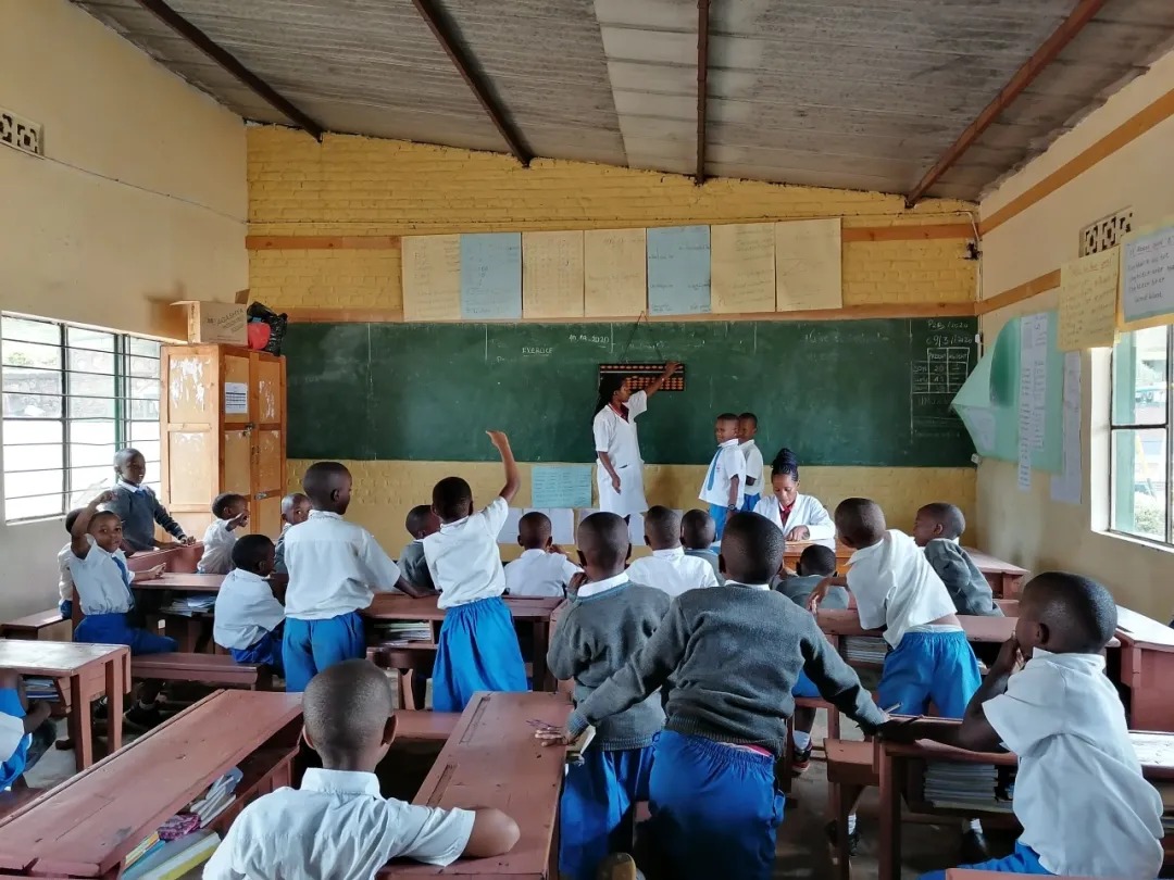 Shenmo Education Rwanda — School partnership class: teacher demonstrating the abacus at the chalkboard.