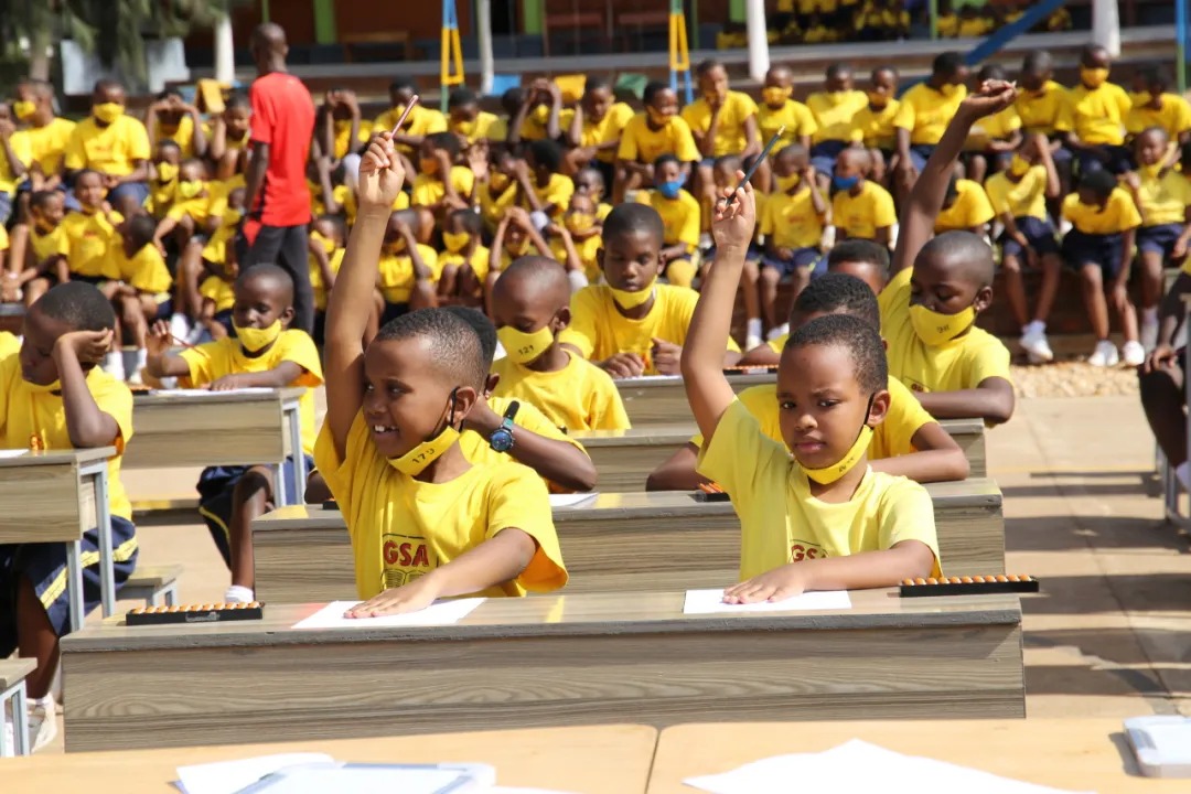 Shenmo Education Rwanda — Outdoor group lesson: partner-school students engaged in abacus practice.
